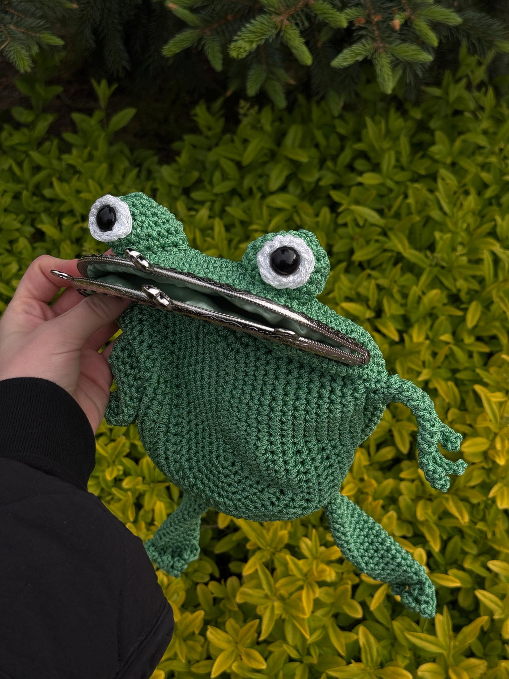 Front view of handmade green crochet frog bag with big eyes and metal clasp