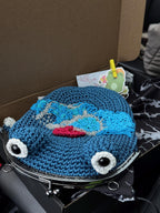 Blue crochet frog bag with wave and red sun embroidery, neatly packed in a box with branded card and sticker