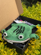 Crochet frog bag sitting in box with tag and packaging