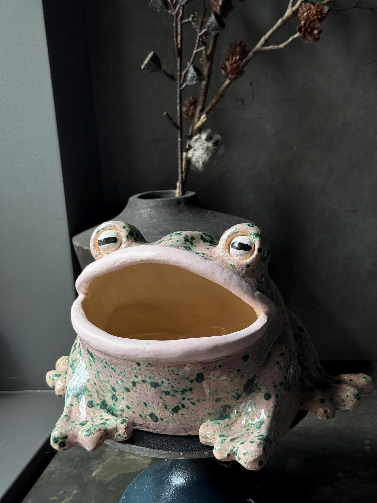 Three-quarter angle of the ceramic frog showing interior and expression